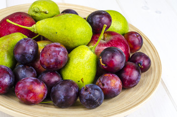 Naklejka na ściany i meble Ripe fruit on wooden plate