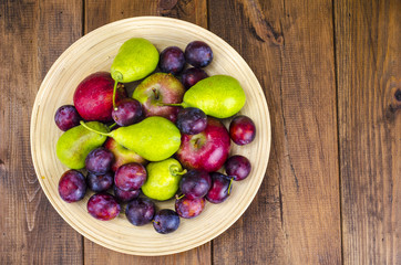 Ripe fruit on wooden plate
