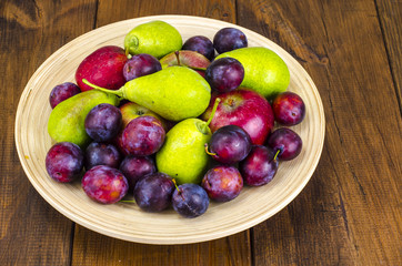 Ripe fruit on wooden plate