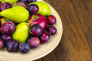 Ripe fruit on wooden plate