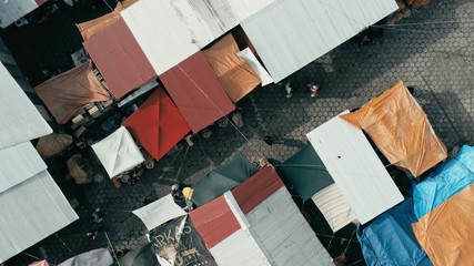 aerial drone image of the morning city market with colorful tents looking down