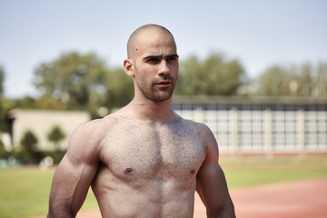 Obraz premium one young muscular man, upper body, outdoors posing, looking at camera, shirtless. bare chest, shirtless. looking forward.