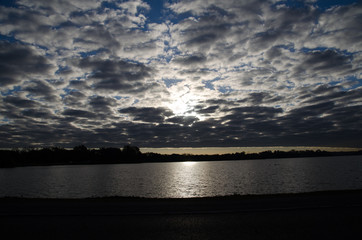 sunset over lake with cloud cover
