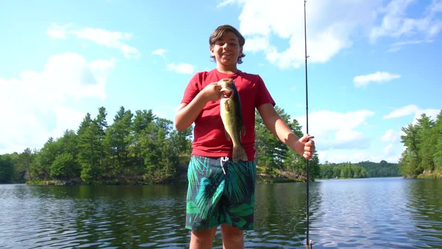 Proud young fisherman holding a nice healthy bass