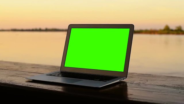 Laptop green screen with sunset.