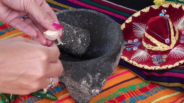 Cutting garllic in a traditional mexican way with molcajete