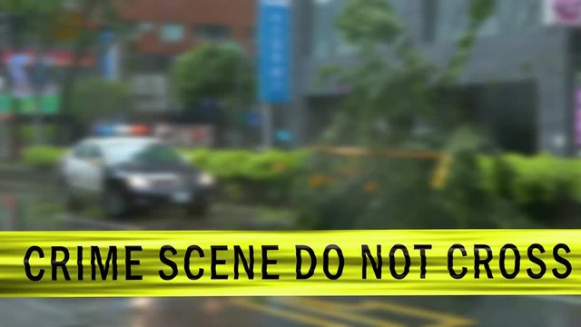 Boundary Tape and Defocused Squad Car at Crime Scene