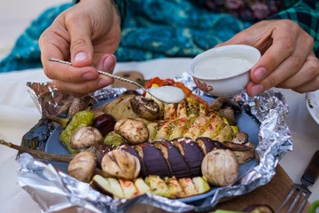 Baked, grilled, roasted vegetables in foil with tartar white sauce. Eggplants, mushrooms, red bell pepper, potato