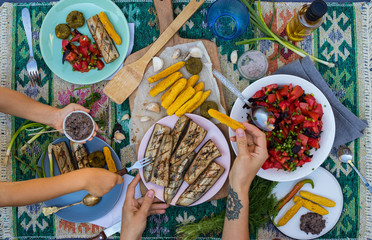 Healthy paleo diet food. Family eat vegan lunch, vegetarian dinner, grilled  roasted vegetables, eggplants, corn bread sticks, fresh summer salad with tomatoes, fresh greens. Mother and daughter hands