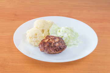 Polish Meatballs knows in Poland as kotlet mielony for dinner Kotlet mielony with mizeria and mashed potatoes. - obrazy, fototapety, plakaty