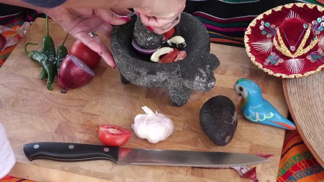 Making mexican salsa in a traditional way with molcajete