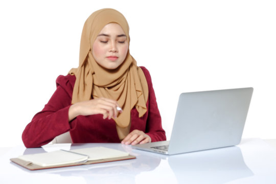 Portrait of pretty Asian hijap woman in front of laptop. Blurred image