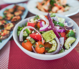 Assorted festive dishes on a wooden table, roasted mushroom, garlic prawns and salads