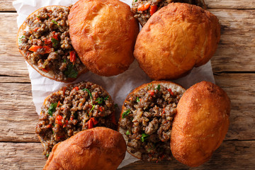 African dish vetkoek: fried yeast dough sandwich with meat curry close-up. horizontal top view