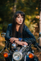 Obraz na płótnie Canvas Girl on a motorcycle in a black jacket and leather pants. Women biker