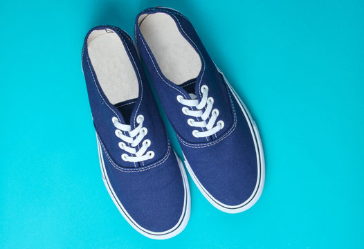 blue sneakers on blue background. Minimalism, fashion, top view.