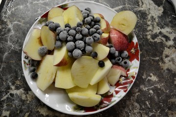 Порезанные яблоки и замороженные ягоды смородины на компот