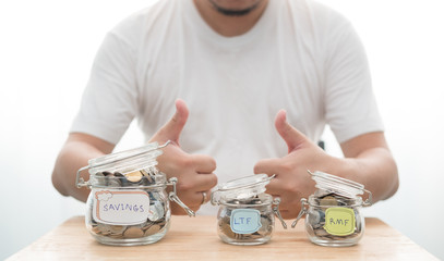 Consent with coins in glass jar saving money. LTF and RMF glass jar with Big glass jar close-up.
