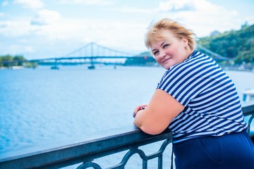 Fototapeta premium Size plus mature lady. Enjoying at day, concept human with excess weight. Senior woman take a rest and have a good mood. Life of xxl people 