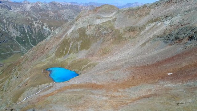 Alpine lake, Vago lake in Valtellina near Livigno (Forcola Pass). Aerial view with drone in high mountain