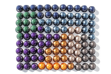 Coffee capsules many colors on a white background isolated top view