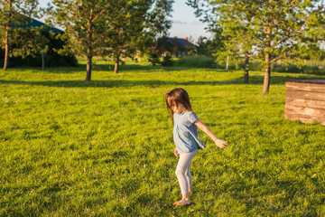 Little happy girl having fun in a summer park.