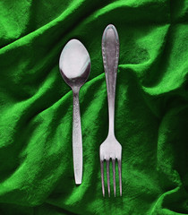 Spoon and fork on  silk tablecloth.