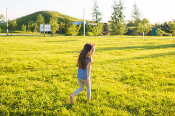 Fototapeta premium Little happy girl having fun in a summer park.