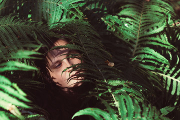 portrait of a woman with blue eyes in fern bushes
