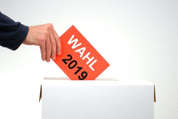 Hand mit Wahlurne und Stimmzettel: Wahl 2019