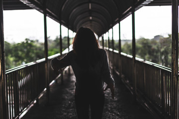 Scary ghost woman image standingbetween the middle of the walkway with a horror background.