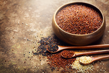 Quinoa. Red, black and white quinoa grains in a wooden bowl. Healthy food. Chenopodium quinoa