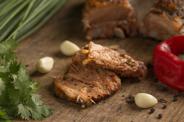 sliced baked meat with aromatic herbs and spices, pepper, garlic, cilantro,  