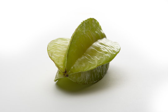 Carambola or star fruit laying with reflection on a desk