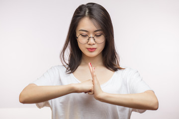 Korean young woman greeting with Thai culture guesture, welcome expression isolated on white background.