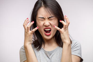 Furious frustrated Asian woman yells loudly, screws up her eyes, gesturing with hands desperately, isolated over white background with copyspace, Negative Emotions and Gestures