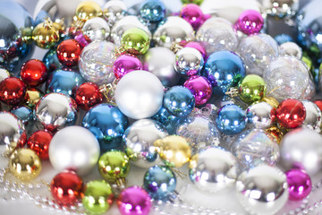 Fototapeta na wymiar Christmas and New Year pattern, ornament of different colors glass decorative balls and tinsel, lights and sparkles, closeup