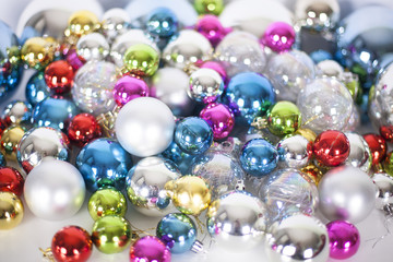 Fototapeta na wymiar Christmas and New Year pattern, ornament of different colors glass decorative balls and tinsel, lights and sparkles, close up
