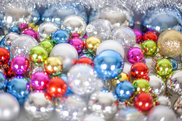 Christmas and New Year pattern, ornament of bright multi-colored glass decorative balls and tinsel, lights and sparkles, closeup