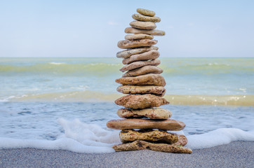 Fototapeta na wymiar Stone tower in the sea waves