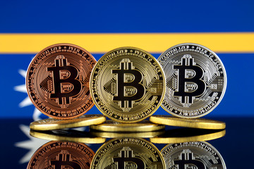 Physical version of Bitcoin (BTC) and Nauru Flag. Conceptual image for investors in High Technology...