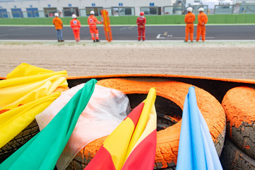 Motor sport warning flags close up on racing circuit barrier