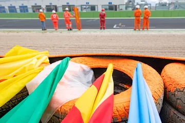 Rolgordijnen Motor sport warning flags close up on racing circuit barrier © fabioderby