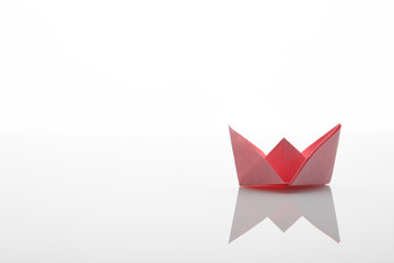 Paper origami red boat on the white background
