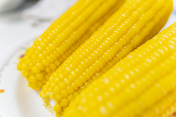 Three Fresh corn on white table, closeup.