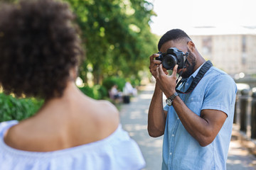African-american photographer taking photos of beautiful woman
