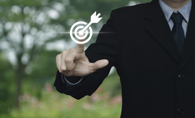 Businessman pressing target with dart flat icon over blur flower and tree in park, Business success concept