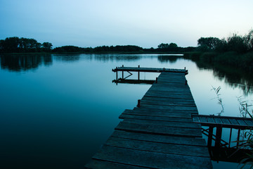 Wooden jetty over a calm mystical lake