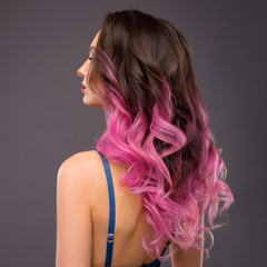 Woman with Long Healthy Colorful Ombre Pink Wavy Hair. Close Up of Hairstyle. Care and Hair Products