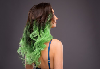Woman with Long Healthy Colorful Green Ombre Wavy Hair. Close Up of Hairstyle. Care and Hair Products